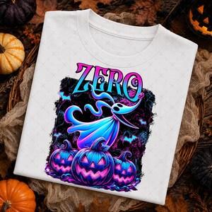 May include: A white t-shirt featuring a graphic print of a blue ghost dog character named Zero above three glowing purple and blue jack-o'-lanterns. The design includes the word ZERO in a stylized blue and pink font against a dark background.