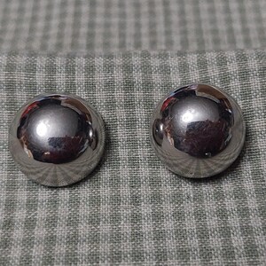 May include: A pair of silver-toned round earrings. The earrings are smooth and shiny.