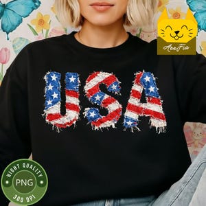 May include: Black sweatshirt with the word "USA" in a distressed, patriotic design. The letters feature a red, white, and blue colour scheme, resembling the American flag. The sweatshirt is a casual style.