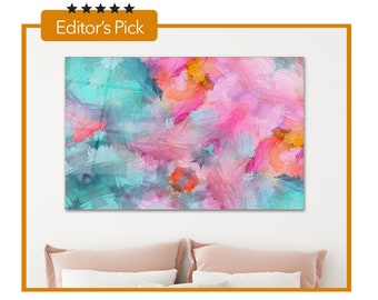 May include: Abstract art print with a vibrant mix of colors. The artwork features brushstrokes in shades of pink, teal, orange, and yellow. The words "Editor's Pick" are in the top left corner. The art is displayed above a bed with pink pillows.