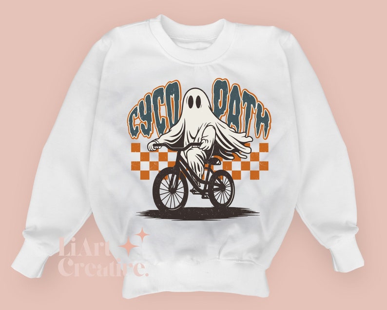 Peut inclure: Sweat-shirt blanc avec un motif d'un fant&ocirc;me &agrave; v&eacute;lo. Le fant&ocirc;me est drap&eacute; d'un drap. Le texte "CYCO PATH" est &eacute;crit dans un style r&eacute;tro. Un motif &agrave; carreaux orange et blanc est derri&egrave;re le fant&ocirc;me.