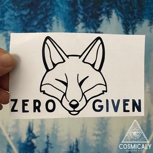 Puede incluir: Una pegatina blanca con un contorno negro de la cara de un zorro y el texto "ZERO GIVEN" en negro.