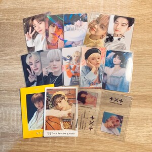 May include: A collection of photo cards featuring a group of young men. The cards are in various colours and designs, and some have text on them. The text on one card reads "The Star Seeker". The text on another card reads "띵똥! 여기 귀요미 오빠 집 맛나용?" which translates to "Ding dong! Is this the cute older brother's house?"