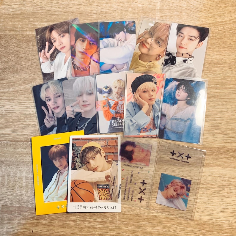 May include: A collection of photo cards featuring a group of young men. The cards are in various colours and designs, and some have text on them. The text on one card reads "The Star Seeker". The text on another card reads "띵똥! 여기 귀요미 오빠 집 맛나용?" which translates to "Ding dong! Is this the cute older brother's house?"