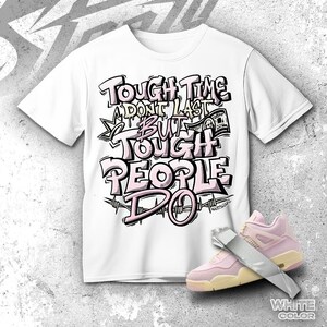 Pode incluir: Camiseta branca com o texto "TOUGH TIMES DON'T LAST BUT TOUGH PEOPLE DO" em um design estilo grafite. A camiseta é combinada com tênis rosa e creme. As palavras são delineadas em preto e rosa.