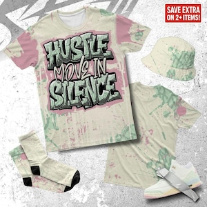 Könnte beinhalten: Eine Streetwear-Kollektion mit T-Shirt, Bucket Hat, Socken und Sneakern. Das T-Shirt zeigt den Text "HUSTLE MOVE IN SILENCE" in einem Graffiti-Stil. Die Artikel haben eine cremefarbene Basis mit rosa und grünen Farbspritzern.