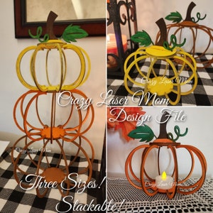 May include: Three wooden pumpkins in different sizes, stacked on top of each other. The pumpkins are painted in shades of orange and yellow. The text "Crazy Laser Mom Design File" is visible in the image.