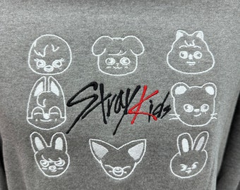 May include: Gray sweatshirt with a white embroidered design of various cartoon animals and the text "Stray Kids" in black and red.