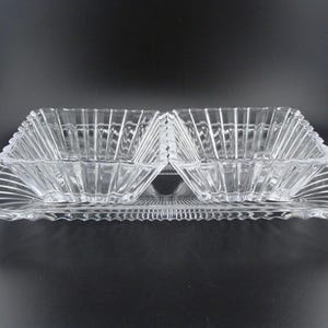 May include: A clear glass serving dish with two smaller bowls. The dish and bowls have a ribbed design.