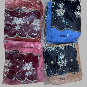 Puede incluir: Cuatro pa&ntilde;uelos de diferentes colores con bordados de perlas y flores. Los pa&ntilde;uelos est&aacute;n empaquetados en pl&aacute;stico y etiquetados con los colores "Pucce Red", "Han Blue", "Turkish Rose" y "Taupe".