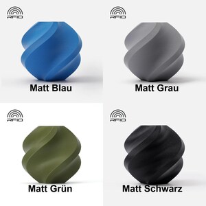 May include: Four different colored, matte finished, twisted, geometric shapes. The colors are blue, gray, green, and black. The shapes are labeled with the color in German.