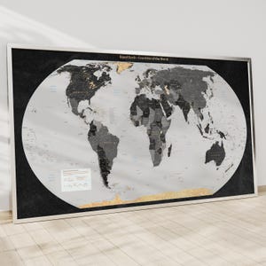 以下が含まれることがあります： 白黒の配色で額装された世界地図。地図には「Equal Earth - Countries of the World」とラベルが付けられ、国の詳細なアウトラインが示されています。フレームはシルバーで、地図は白い壁に表示されています。