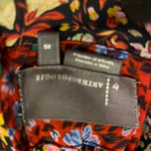 May include: A black and red floral print fabric with a grey tag that reads "ANTHROPOLOGIE" and "XS".