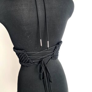 Back view of the black luxurious macramé top with metallic details, featuring a lace-up corset-style design, highlighting intricate handmade craftsmanship and a bold, stylish look.