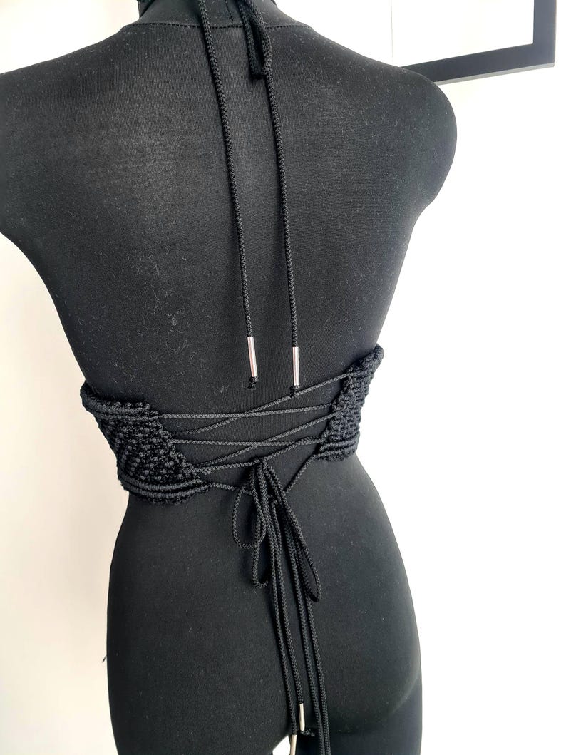 Back view of the black luxurious macramé top with metallic details, featuring a lace-up corset-style design, highlighting intricate handmade craftsmanship and a bold, stylish look.