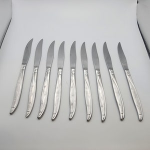 May include: Set of ten silver dinner knives with a floral design on the handle.