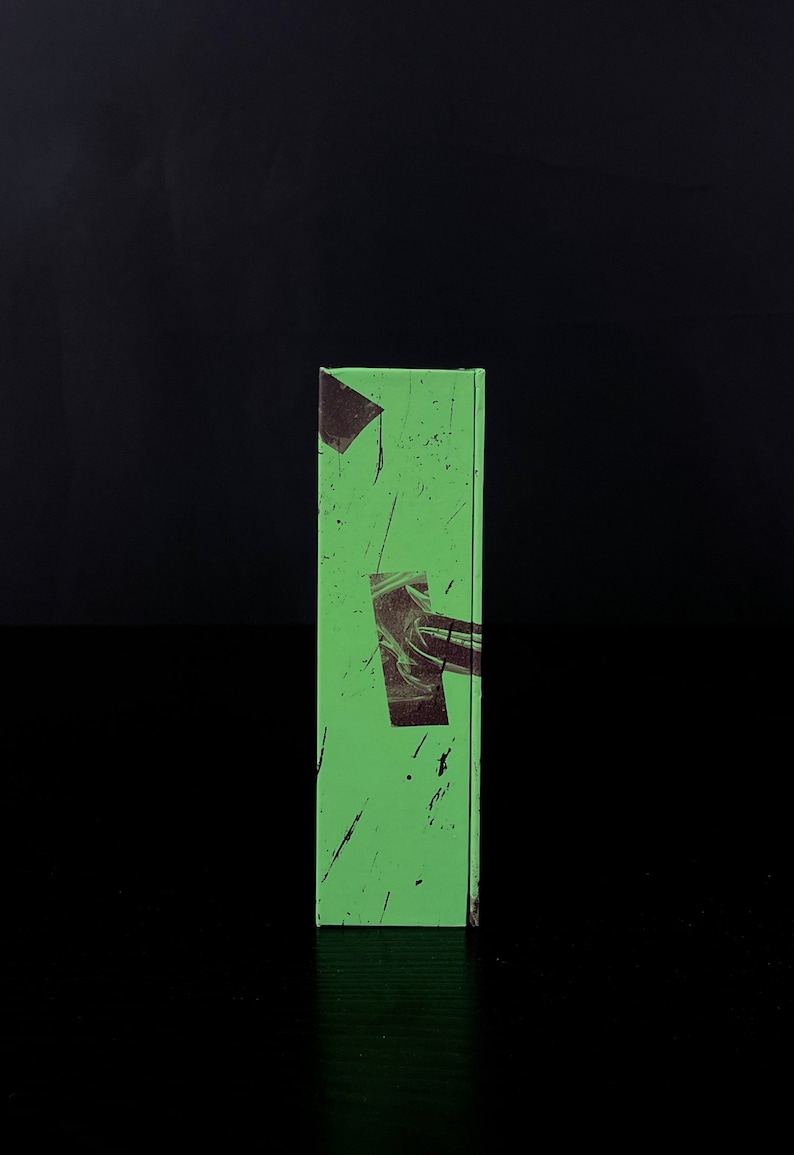 May include: A green book with black and white abstract designs on the cover.
