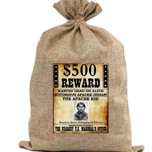 May include: A burlap sack tied at the top, with a vintage-style wanted poster affixed to the front. The poster reads "$500 REWARD" and features a portrait of a man, with text stating "Wanted Dead or Alive! Notorious Apache Indian! The Apache Kid."