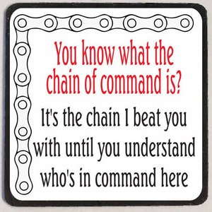 May include: A white square sign with a black border and a black chain design around the edges. The sign has red text that reads "You know what the chain of command is? It's the chain I beat you with until you understand who's in command here."