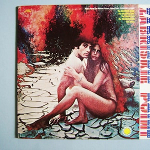 May include: Vintage vinyl record album cover for the soundtrack of the film Zabriskie Point. The cover features a couple embracing, with a colorful, abstract background. The album title is in a vertical, patriotic design.
