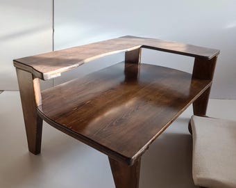 May include: A dark brown wooden table with a two-tiered design featuring a lower rectangular surface and an elevated, narrower upper shelf supported by vertical wooden legs. The wood grain is visible throughout the polished finish.