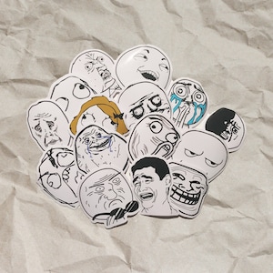 May include: A collection of 14 black and white meme stickers featuring various facial expressions. The stickers are printed on white paper and have a glossy finish.