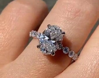Anillo de compromiso de moissanita ovalada con halo oculto en oro de 14 quilates.