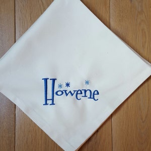 Peut inclure: Serviette en lin blanc avec broderie bleue du nom "Howene" avec deux étoiles bleues.