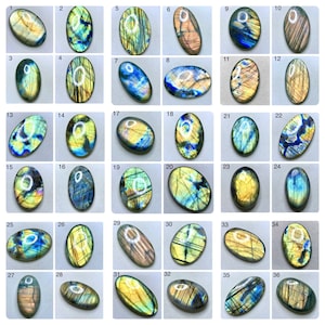 May include: A collection of 36 oval-shaped labradorite gemstones, each with unique patterns and colors. The stones display a range of hues, including blues, greens, yellows, and golds, with iridescent flashes. The gemstones are arranged on a light gray surface.