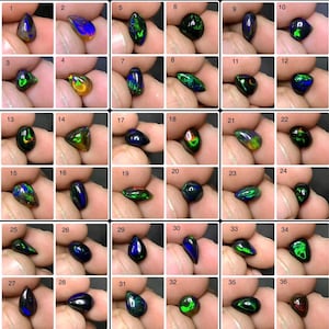 Puede incluir: Una colección de treinta y seis piedras preciosas de ópalo negro, cada una sostenida en una mano. Los ópalos muestran una variedad de formas y tamaños, con destellos vibrantes de color, incluyendo verde, azul y naranja. Las piedras están numeradas.