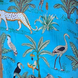 Puede incluir: Una tela de color azul brillante con un patr&oacute;n repetitivo de animales salvajes y plantas tropicales. El estampado incluye un guepardo, cebras, un flamenco, un tuc&aacute;n, una cacat&uacute;a y un p&aacute;jaro peque&ntilde;o, entre palmeras y follaje verde.