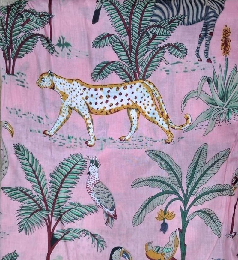 Puede incluir: Una tela de color rosa claro con un patr&oacute;n repetitivo de animales salvajes y plantas tropicales. El dise&ntilde;o incluye un leopardo moteado, una cebra, una cacat&uacute;a y varias palmeras y suculentas impresas en tonos verdes, amarillos y negros.