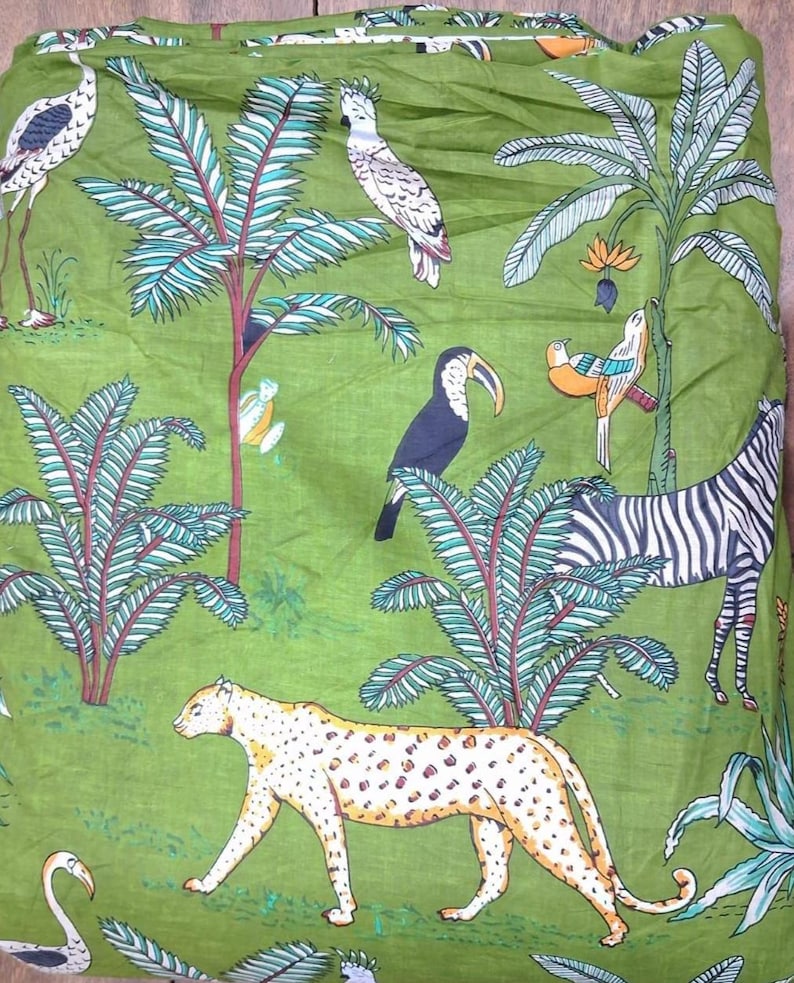 Puede incluir: Una tela verde con un estampado repetitivo de tem&aacute;tica selv&aacute;tica. El dise&ntilde;o incluye un leopardo, una cebra, un tuc&aacute;n, una cacat&uacute;a blanca y un ave de patas largas entre palmeras y follaje tropical, en tonos verdes, blancos, negros y naranjas.