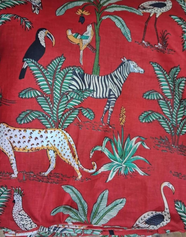 Puede incluir: Una tela roja con un patr&oacute;n repetitivo de varios animales y plantas. El dise&ntilde;o incluye un tuc&aacute;n negro, un p&aacute;jaro amarillo y azul, una cebra blanca y negra, un leopardo manchado y dos p&aacute;jaros blancos, intercalados con palmeras verdes.