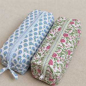 K&ouml;nnte beinhalten: Zwei rechteckige Federm&auml;ppchen. Eines ist wei&szlig; mit blauem Blumenmuster und blauem Streifenrei&szlig;verschluss. Das andere ist wei&szlig; mit rosa Blumenmuster und gr&uuml;nem Streifenrei&szlig;verschluss. Beide haben einen Rei&szlig;verschluss.