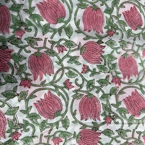 K&ouml;nnte beinhalten: Wei&szlig;er Stoff mit einem sich wiederholenden Muster aus rosa Bl&uuml;ten und gr&uuml;nen Bl&auml;ttern und Ranken. Das florale Design ist auf den Stoff gedruckt. Die Bl&uuml;ten sind gro&szlig; und detailliert, mit einem strukturierten Aussehen. Die Bl&auml;tter und Ranken erzeugen ein flie&szlig;endes, organisches Design.
