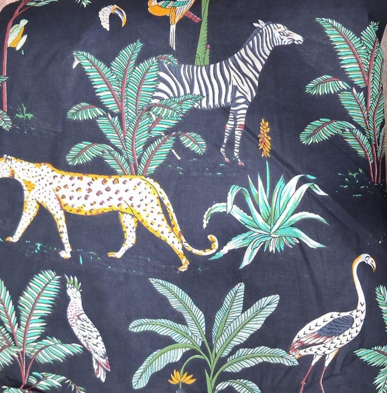 Puede incluir: Una tela negra con un patr&oacute;n repetitivo de una cebra blanca y negra, un leopardo amarillo con manchas negras y una grulla blanca. El dise&ntilde;o incluye hojas de palmera verdes, varias plantas tropicales y peque&ntilde;os p&aacute;jaros coloridos.