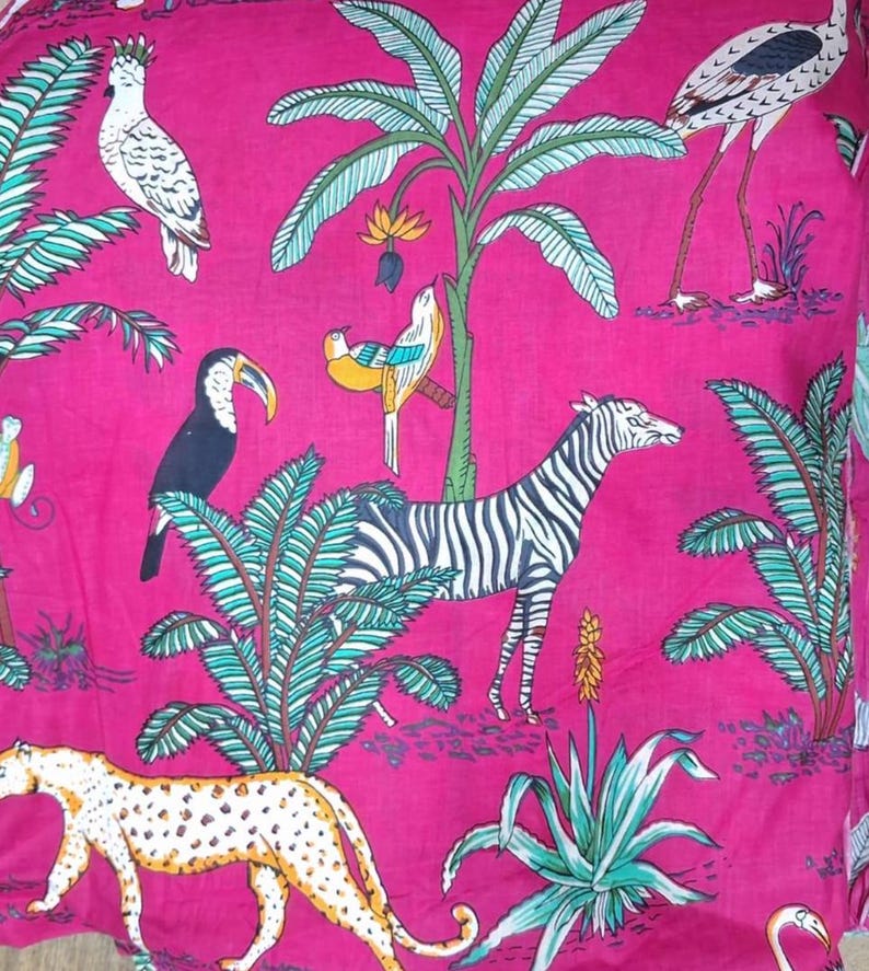 Puede incluir: Una tela de color fucsia vibrante con un patr&oacute;n repetitivo de flora y fauna tropical. El dise&ntilde;o incluye una cebra blanca, un leopardo manchado, un tuc&aacute;n, una cacat&uacute;a blanca y un ave de patas largas, rodeados de palmeras verdes.
