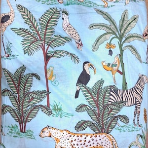 Puede incluir: Una tela azul claro con un patr&oacute;n repetitivo de animales de la selva y plantas tropicales. El estampado incluye un guepardo, una cebra, un tuc&aacute;n, una cacat&uacute;a y un flamenco, intercalados con palmeras y follaje en tonos verdes, amarillos y negros.