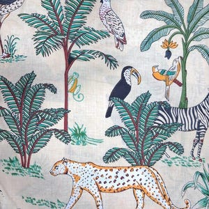 Puede incluir: Una tela de color claro con un estampado repetitivo de tem&aacute;tica selv&aacute;tica. El dise&ntilde;o incluye un leopardo caminando, una cebra, un tuc&aacute;n, una cacat&uacute;a y un flamenco entre palmeras verdes y follaje tropical con troncos y tallos rojos.