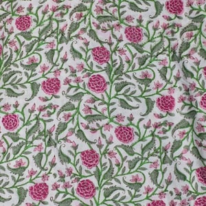 K&ouml;nnte beinhalten: Wei&szlig;er Stoff mit einem sich wiederholenden Blumenmuster. Das Design zeigt gro&szlig;e, leuchtend rosa pfingstrosenartige Bl&uuml;ten, kleinere rosa Knospen sowie gr&uuml;ne Bl&auml;tter und Stiele. Die Gesamt&auml;sthetik ist ein klassischer, botanischer Druck.
