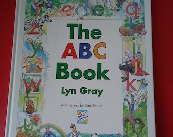May include: A white book with a colorful illustration of the alphabet on the cover. The title is "The ABC Book" by Lyn Gray with verses by Ian Souter. The book is part of the Belair Publications collection.