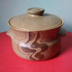 May include: A brown ceramic casserole dish with a lid. The dish has a brown and black swirl design.