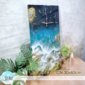 K&ouml;nnte beinhalten: Eine rechteckige Wanduhr mit einem Harz-Ozean-Design. Das Zifferblatt zeigt eine blau-wei&szlig;e Ozeanszene mit goldfarbenen Zeigern und Markierungen. Die Uhr misst 30 x 60 cm und tr&auml;gt den Text "CN 30x60cm".