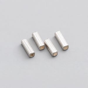 Könnte beinhalten: Vier kleine, silberfarbene Metallperlen in rechteckiger, röhrenartiger Form. Jede Perle hat eine hohle Mitte und eine glatte, metallische Oberfläche. Die Perlen sind in einer Reihe angeordnet und zeigen ihre längliche, vierseitige Struktur.