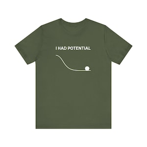 May include: Olive green t-shirt with the text "I HAD POTENTIAL" above a white line and a white ball graphic. The shirt is a short-sleeved crew neck style.