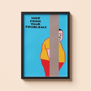 May include: Framed art print featuring a cartoon illustration. The artwork depicts a person partially obscured by a vertical gray stripe, wearing a yellow shirt and red pants. The text "HIDE FROM YOUR PROBLEMS" is displayed in black letters on a blue background.