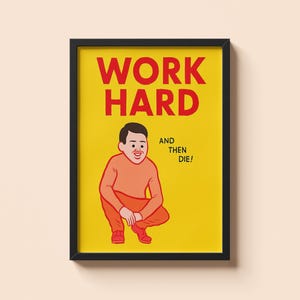 May include: Framed poster with a yellow background and the words "WORK HARD" in large red letters. Below, a cartoon figure in orange clothing squats, with the text "AND THEN DIE!" to the right. The frame is black.