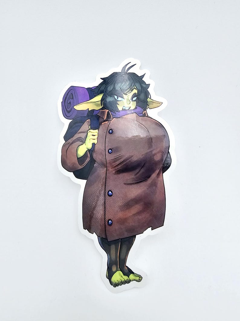 May include: A sticker featuring a cartoon goblin character with green skin, black hair, and pointed ears. The goblin wears a brown coat and carries a purple rolled-up blanket on its back. The sticker has a white border.