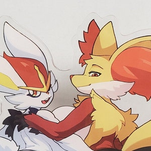 Puede incluir: Una pegatina transparente con dos personajes de dibujos animados abrazándose. Un personaje es blanco con detalles rojos y amarillos, el otro es amarillo, rojo y naranja. La pegatina tiene un acabado brillante y está sobre un fondo blanco.